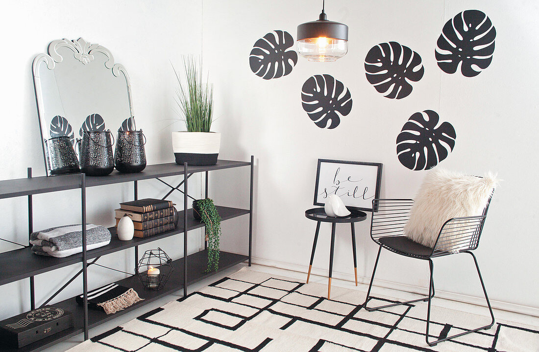 Wohnraumecke in Schwarz-Weiß gestaltet mit Designerstuhl und Wandregal