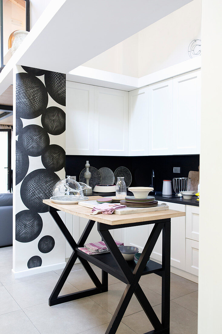 Modern, black and white kitchen behind partition wall in loft apartment