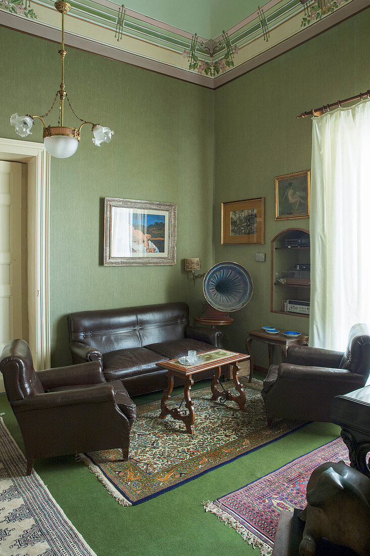 Leather sofa set and antique gramophone in seating area in music room