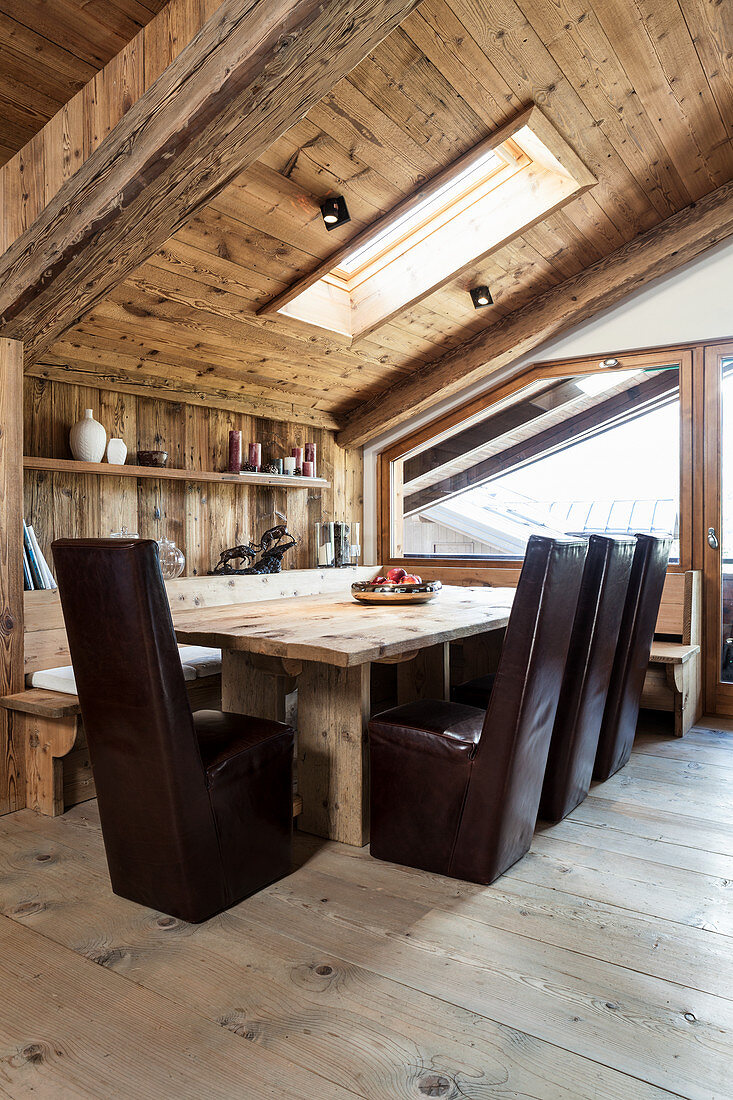 Dunkle Lederstühle am Esstisch mit Eckbank im modernen Holzhaus