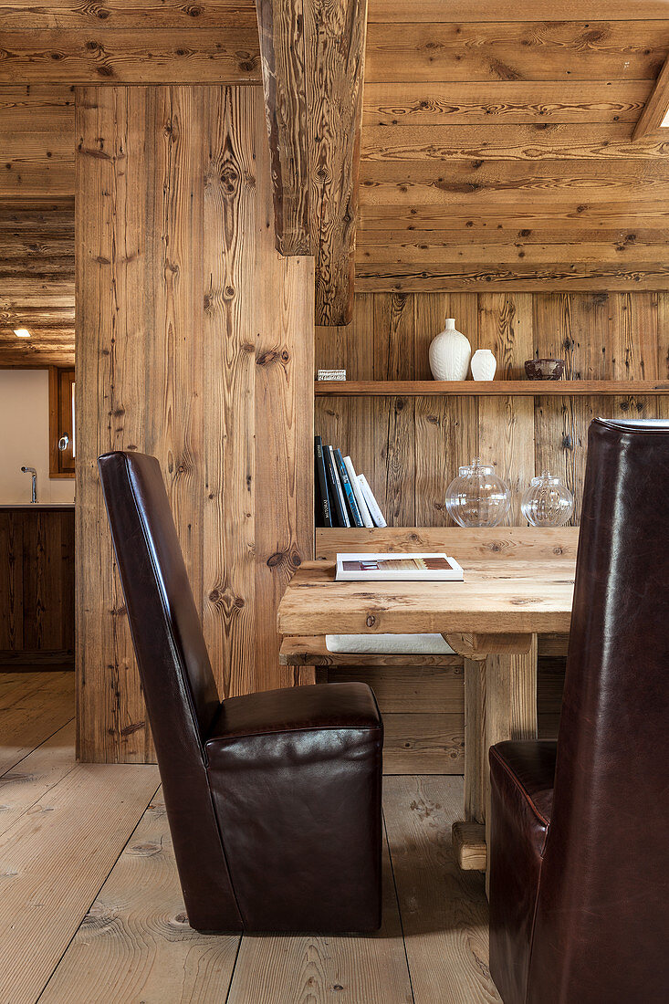 Dunkle Lederstühle am Esstisch im modernen Holzhaus