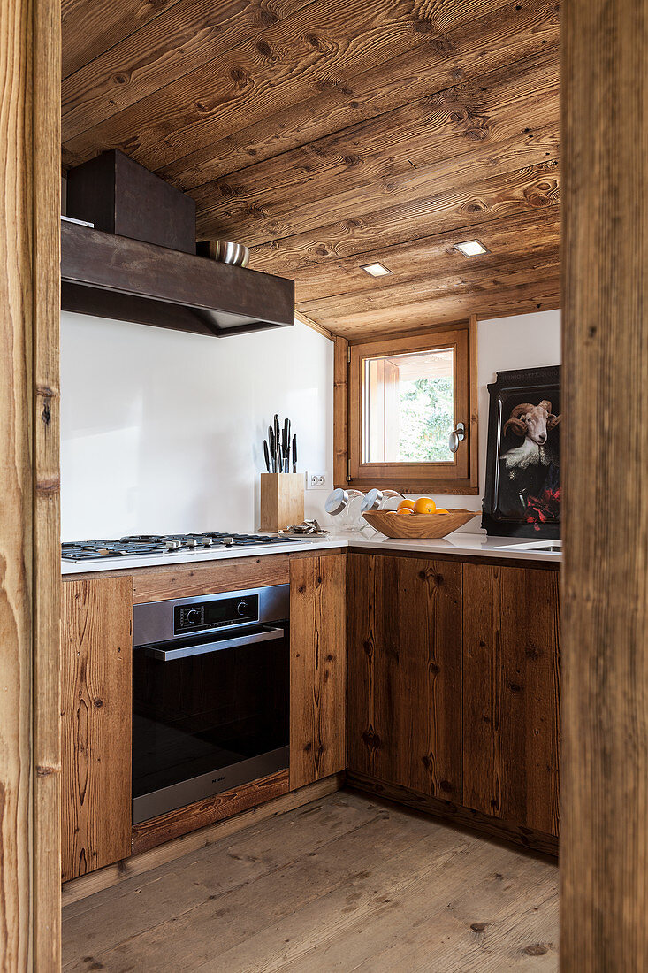Moderne Einbauküche mit rustikalen Holzfronten und Dachschräge