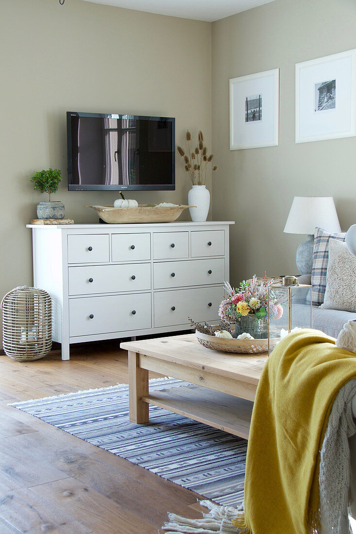 White sideboard and TV in autumnal, country-house-style living room