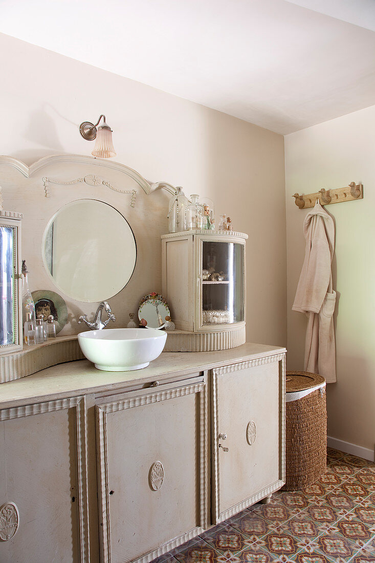 Vintage washstand with integrated mirror and cupboards in top section in bathroom