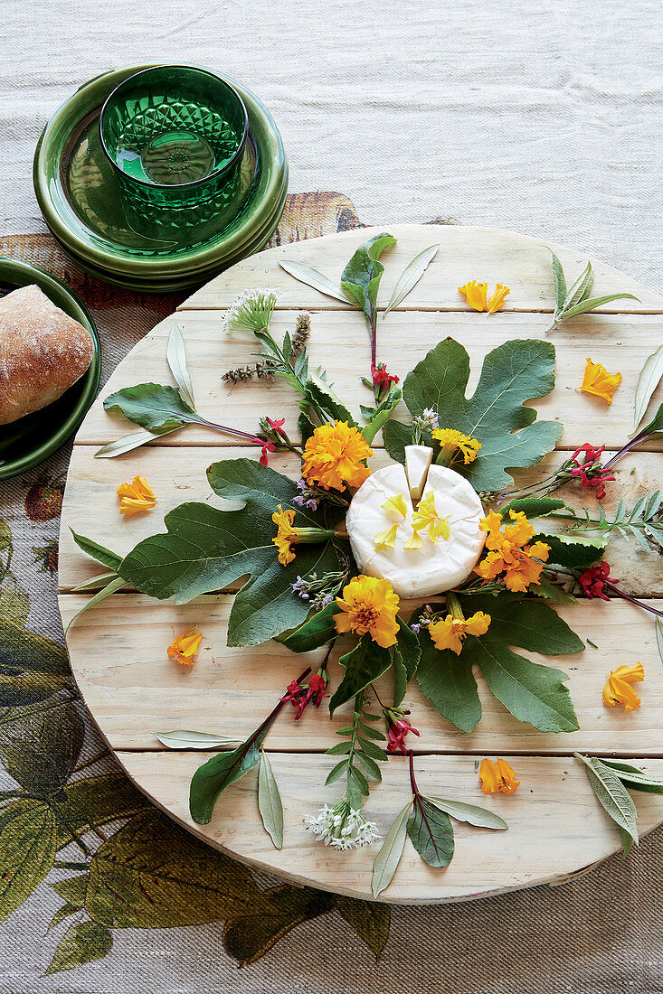 Cheese board decorated with leaves and flowers