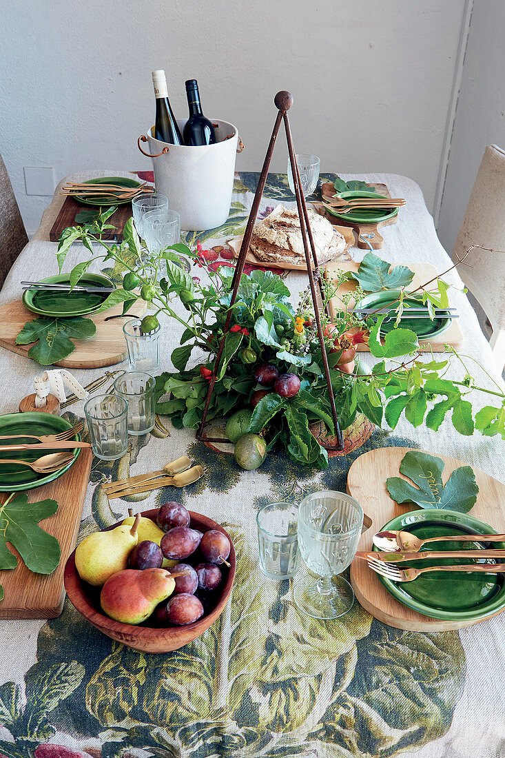 Herbstlich gedeckter Tisch mit Feigenblättern und Gesteck