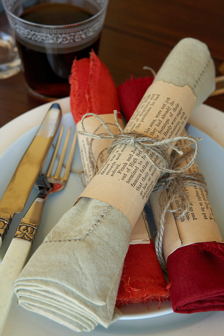 Selbstgebastelte Serviettenringe aus alten Buchseiten als Tischdeko
