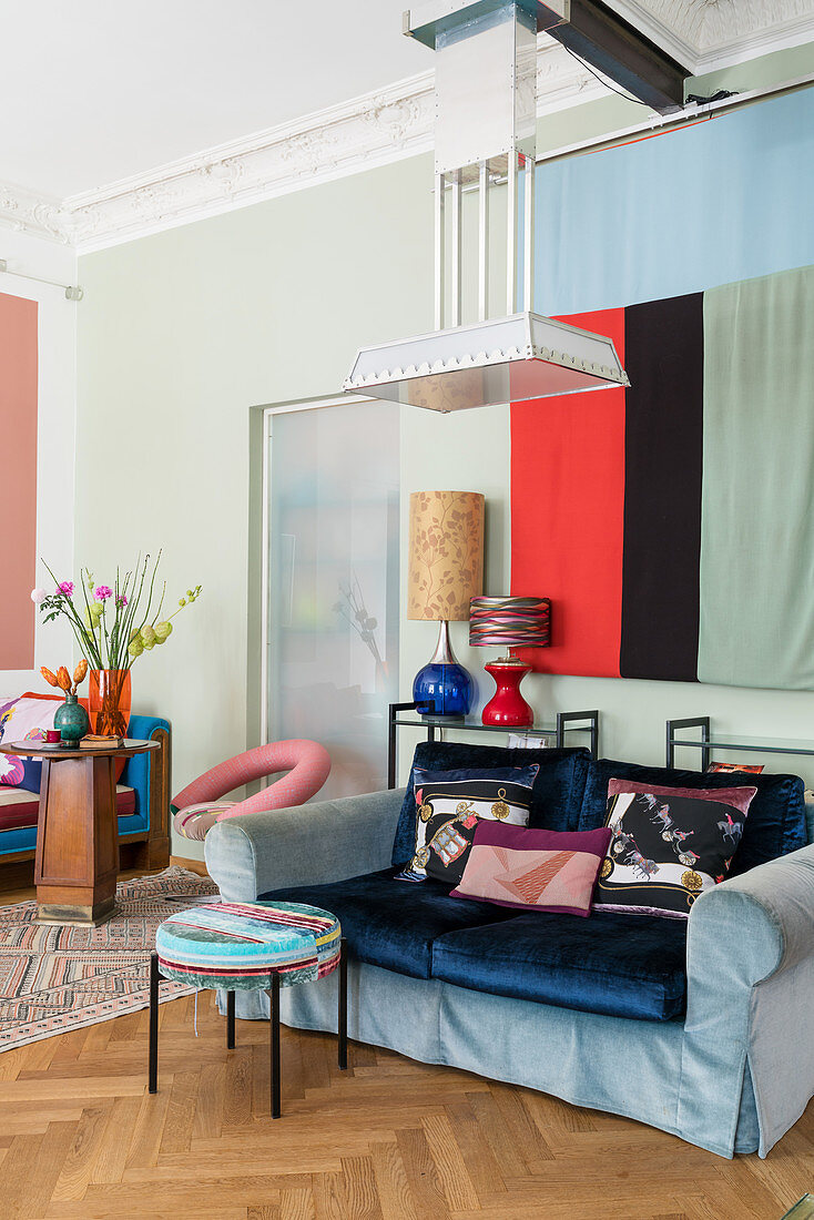 Hussensofa, Beistelltisch und Wandbehang im Wohnzimmer