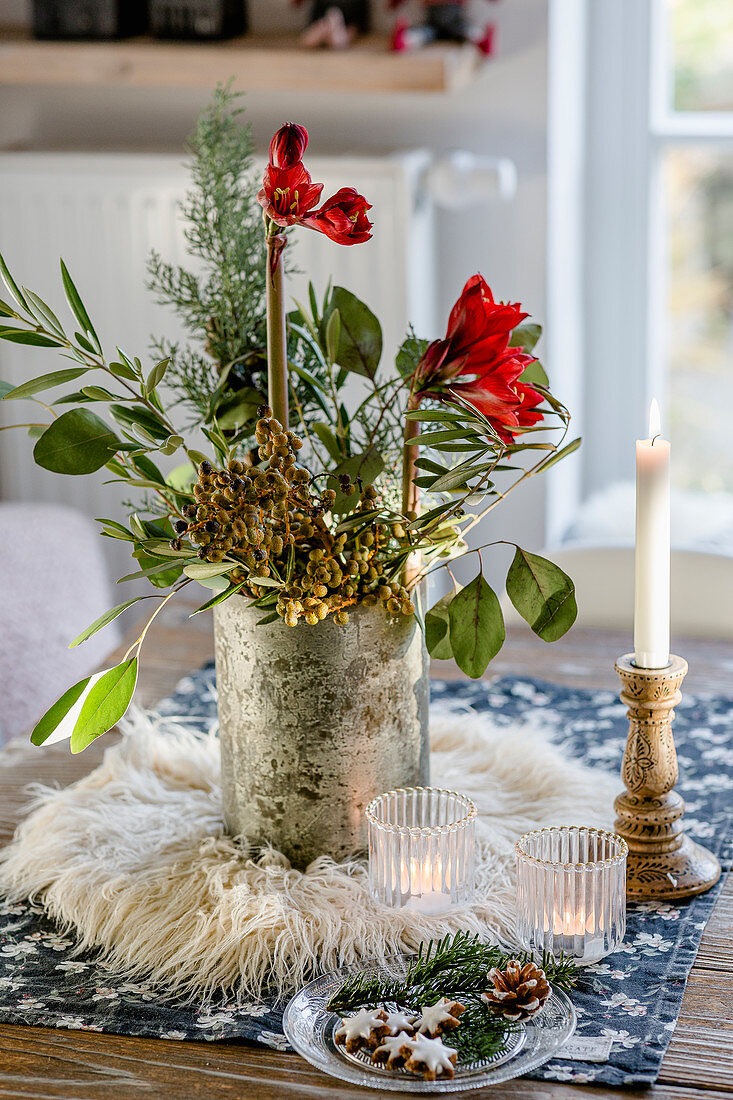 Winterlicher Strauß mit Zweigen und Amaryllis auf dem Tisch