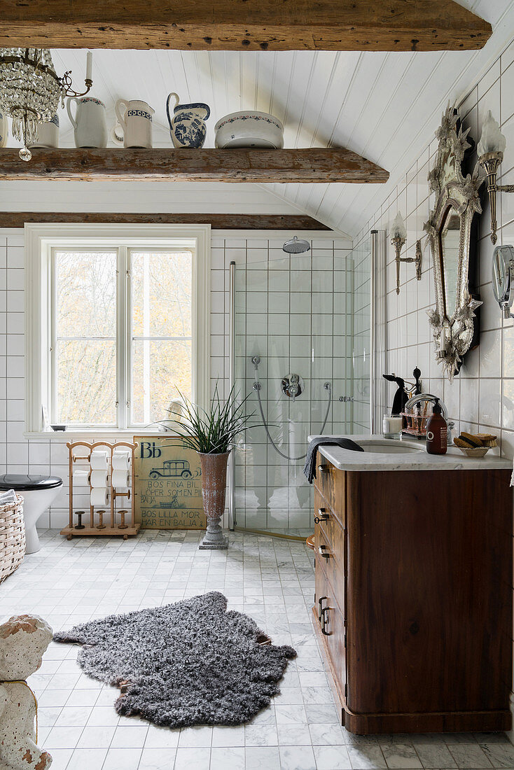 Wooden ceiling beams in large white bathroom decorated in vintage style