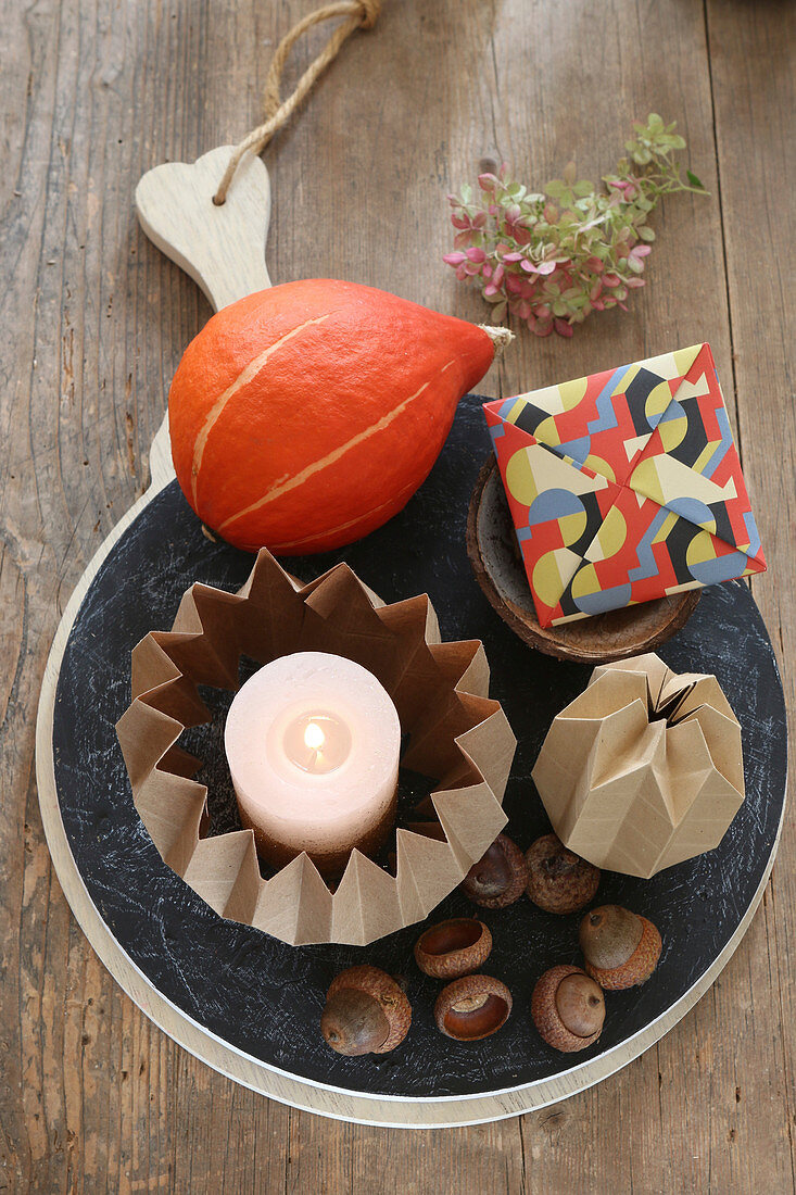 Autumnal arrangement of origami candle holder, pumpkin and envelope