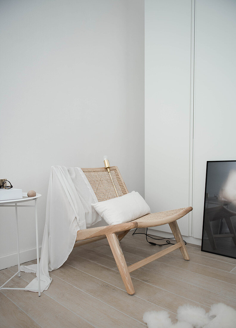 Relax-Stuhl aus Holz mit Flechtbespannung in Zimmerecke