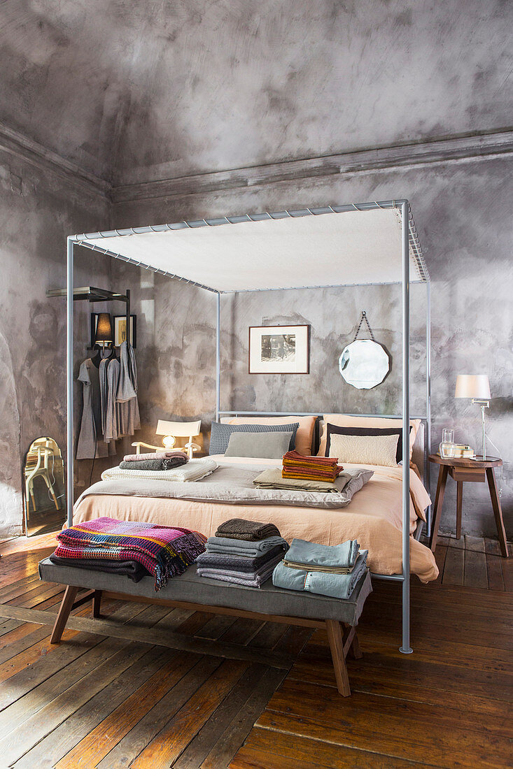 Modernes Metall-Himmelbett davor Decken und Bettwäsche auf Bettbank