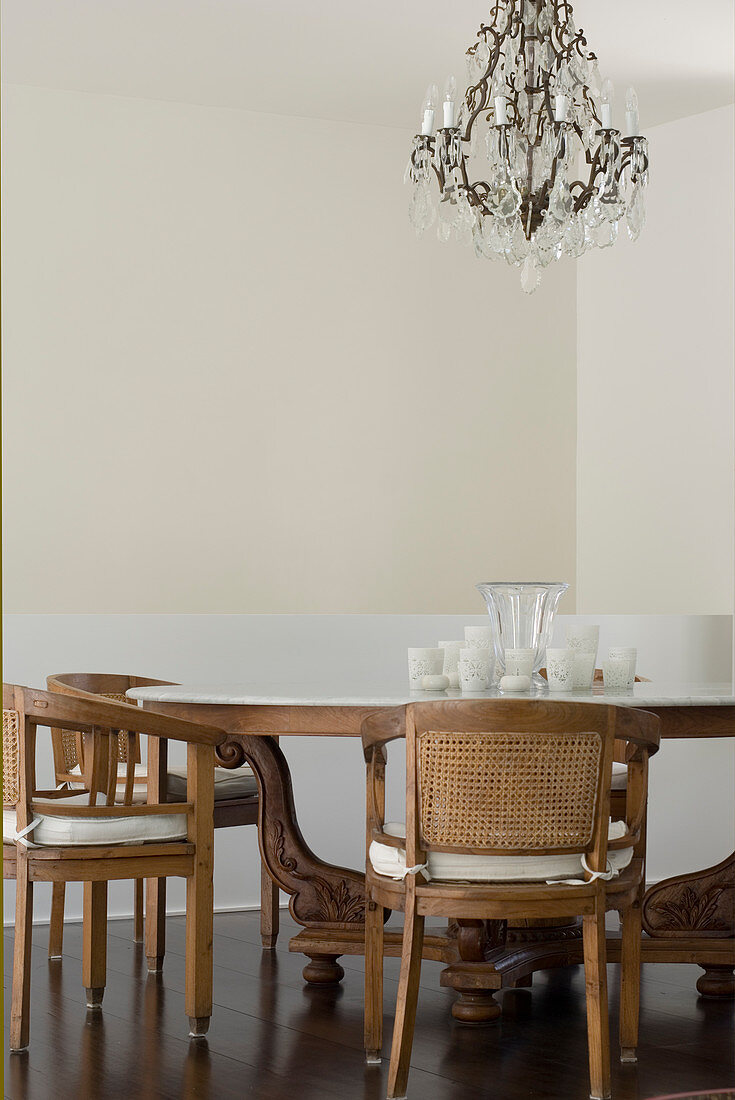 Antique dining table and chairs below chandelier in dining room