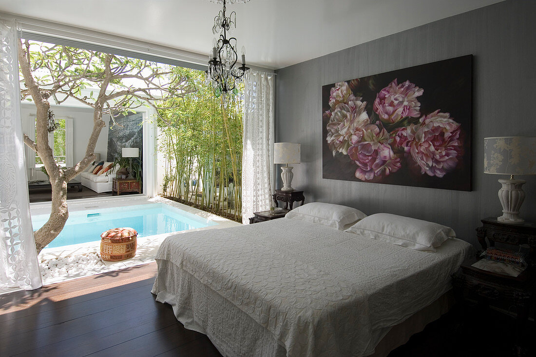 Bild mit Blumenmotiv über Doppelbett, Blick auf Pool