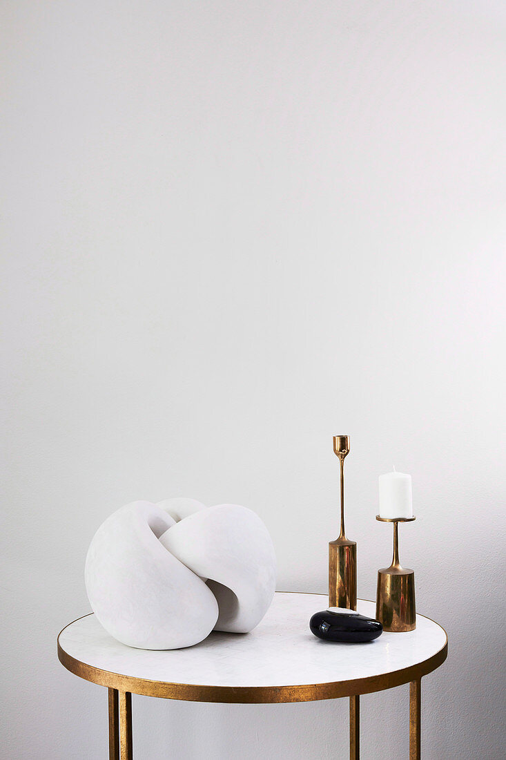 Side table with modern sculpture and candle holders