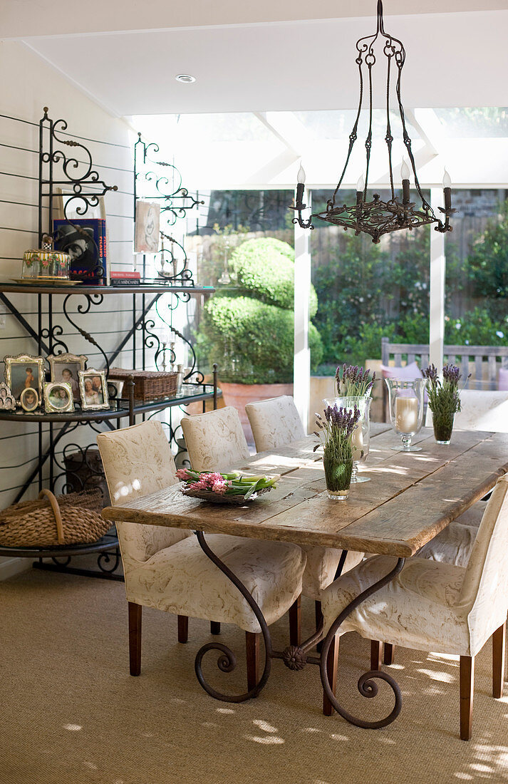 Wooden table and chairs with cream upholstery in country-house-style dining area