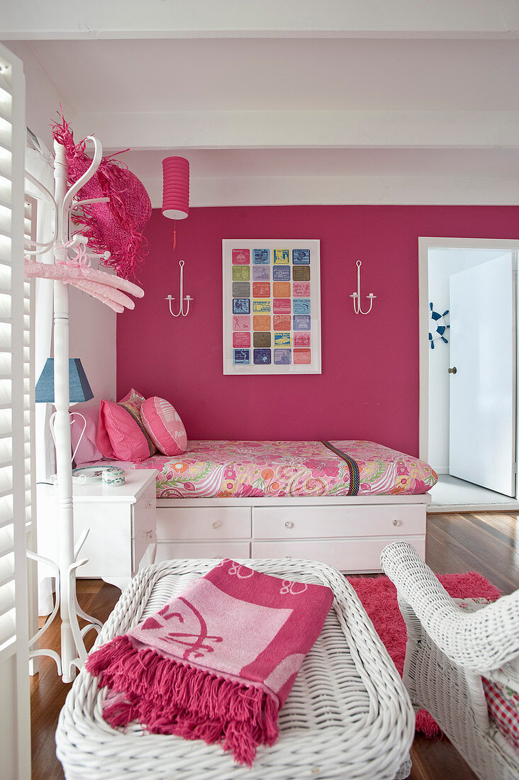 Feminines Schlafzimmer in Pink und Weiß mit Einzelbett und Rattanmöbeln