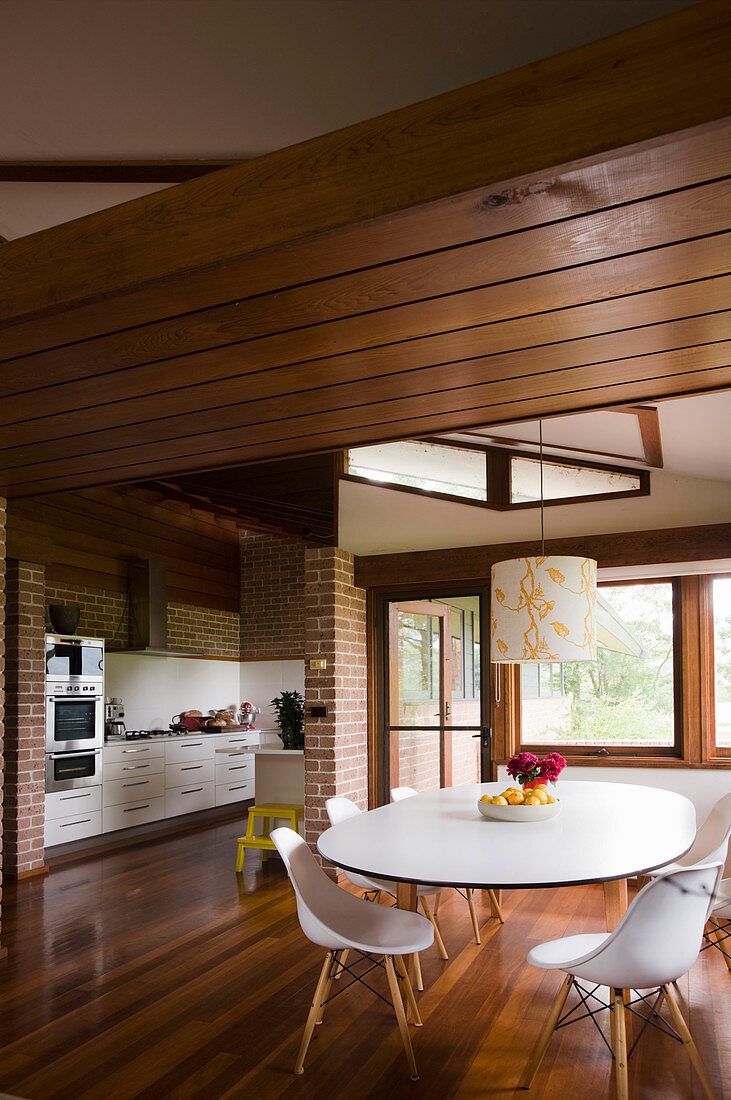 Wohnraum mit offener Küche und Essbereich unter abgehängter Holzdecke