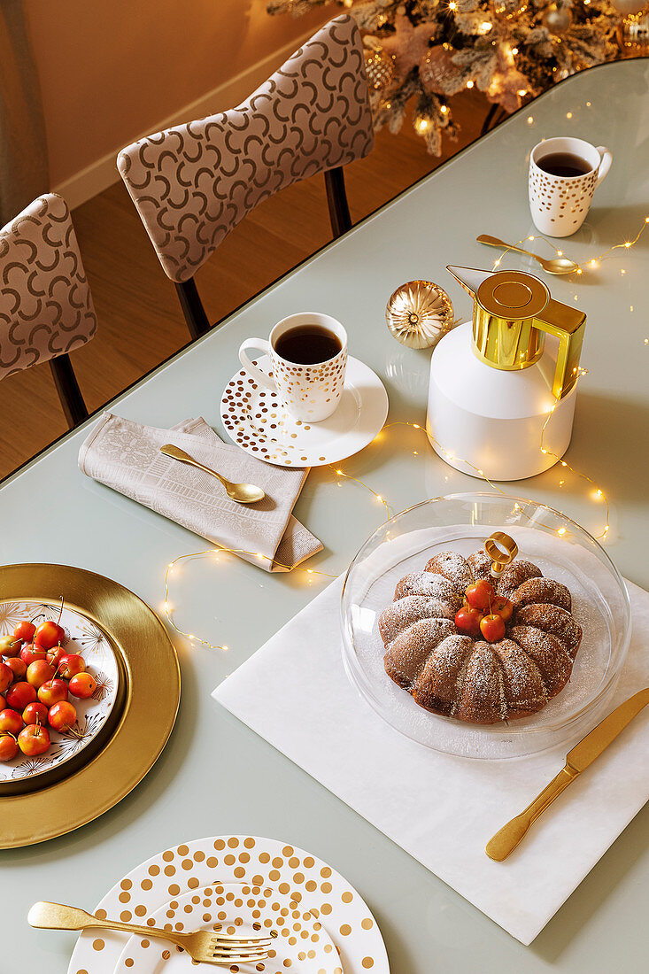Coffee and cake on festively set table in gold and white