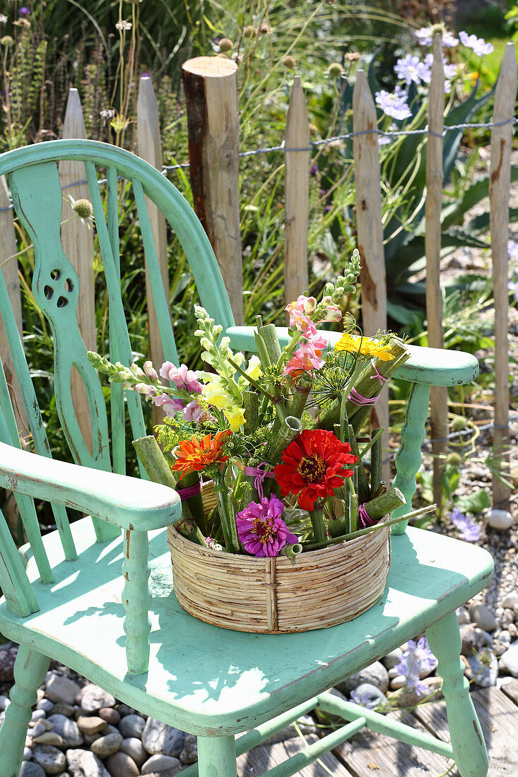 Arrangement of knotweed, snapdragons and zinnias in basket