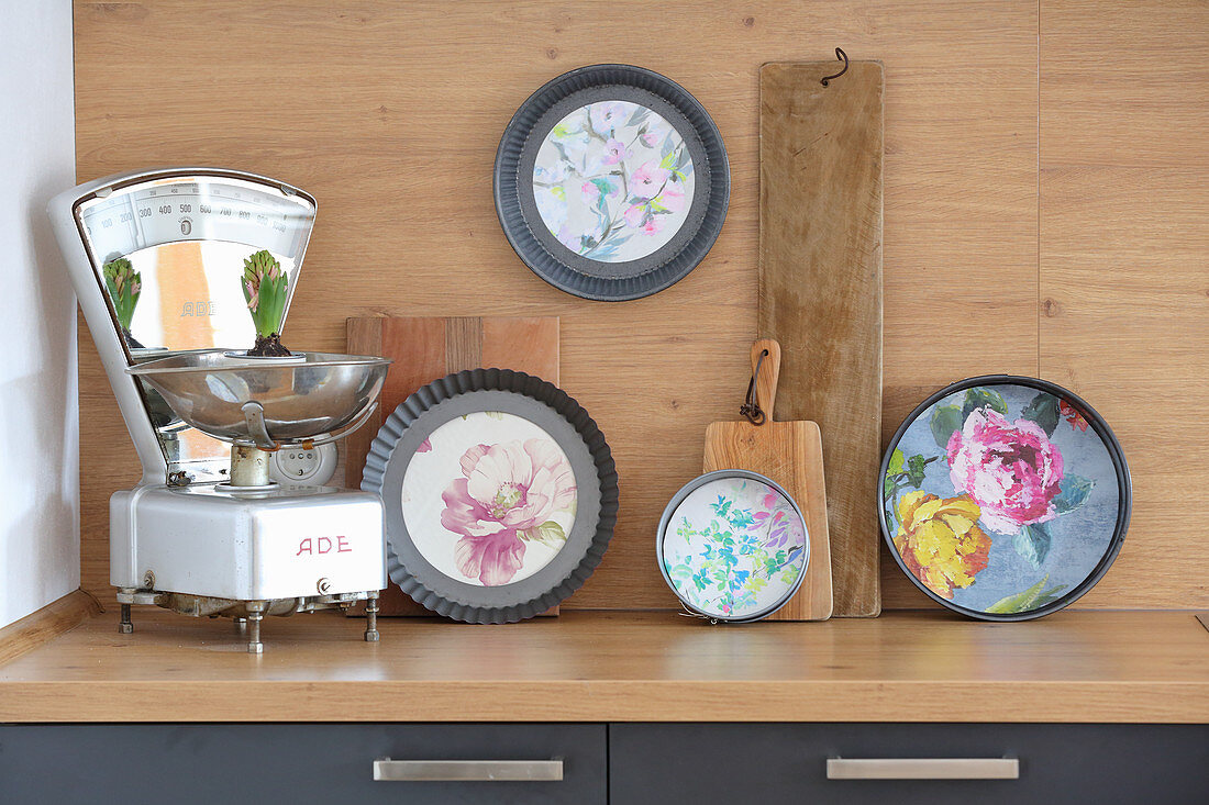 DIY arrangement of cake tins decorated with floral wallpaper and old kitchen scales