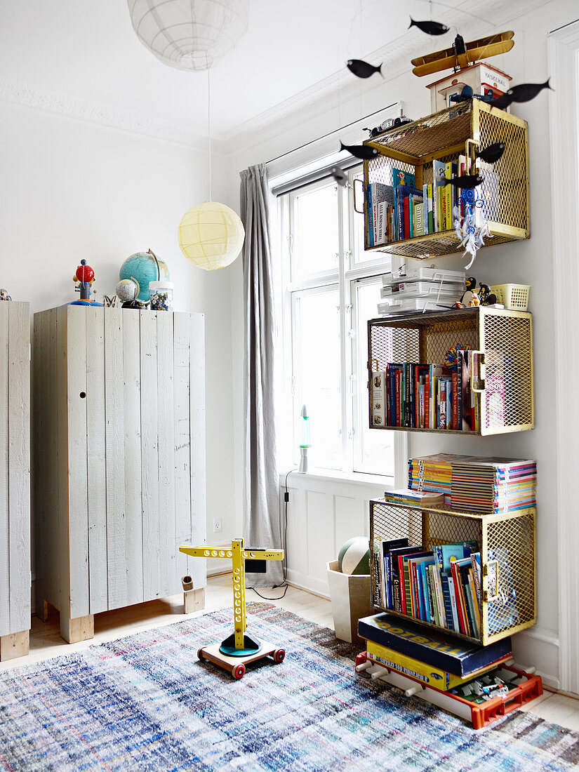 Shelving modules made from gold-painted baskets and wooden wardrobes in children's bedroom