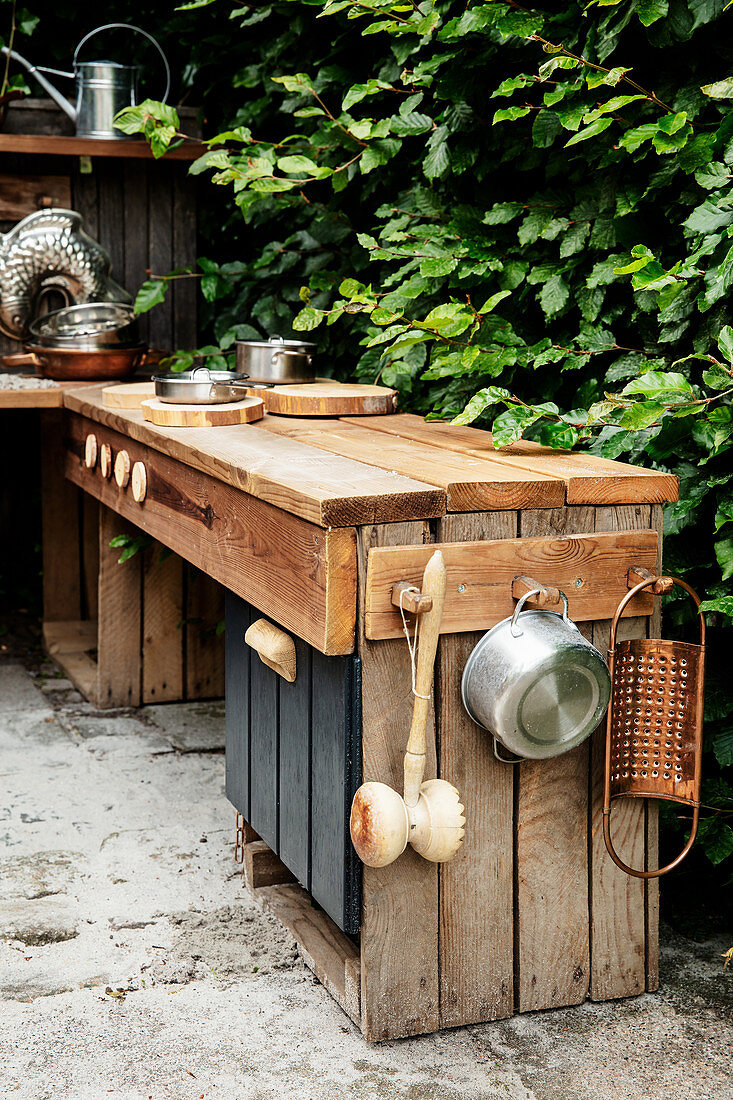 DIY outdoor play kitchen made from reclaimed wood on terrace