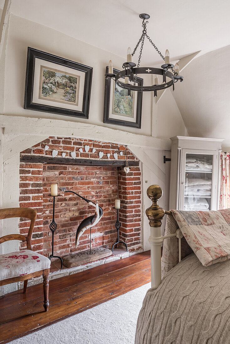 Red-brick fireplace with antique chair upholstered