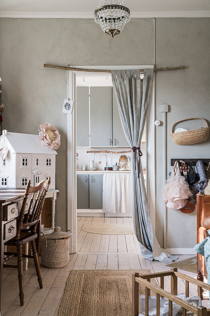Schreibtisch mit Stuhl und Puppenhaus im Mädchenzimmer mit Durchgang zur Küche