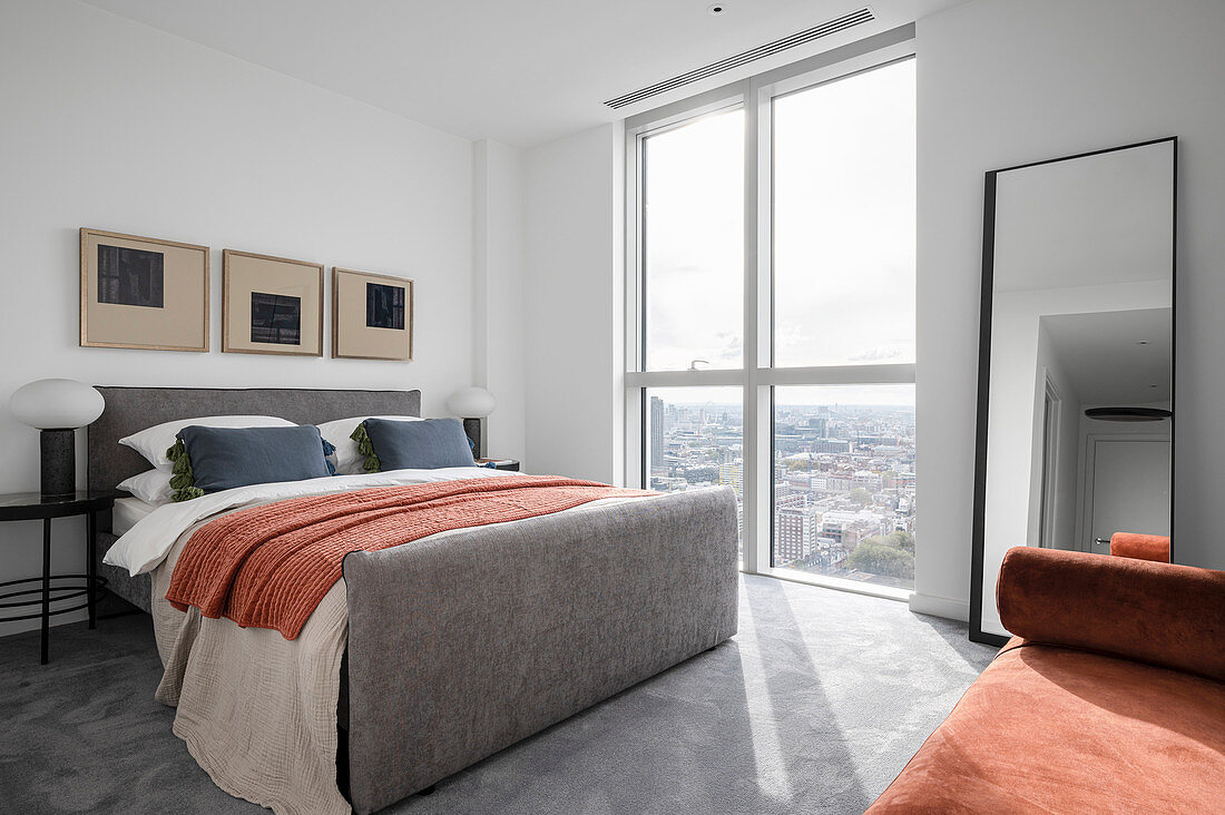 Modern bedroom in gray tones with orange accents