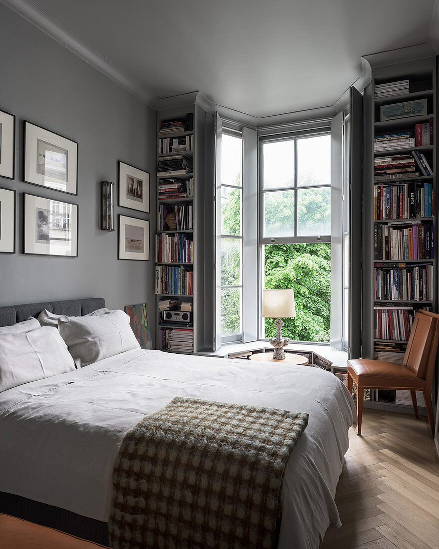 Bookcases flanking bay window in classic, grey bedroom