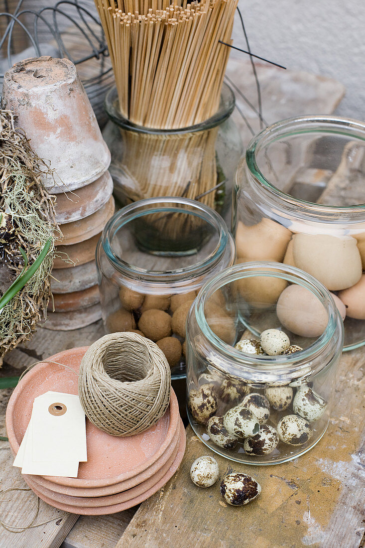 Jars of craft materials such as eggs, wooden spills, terracotta pots and twine