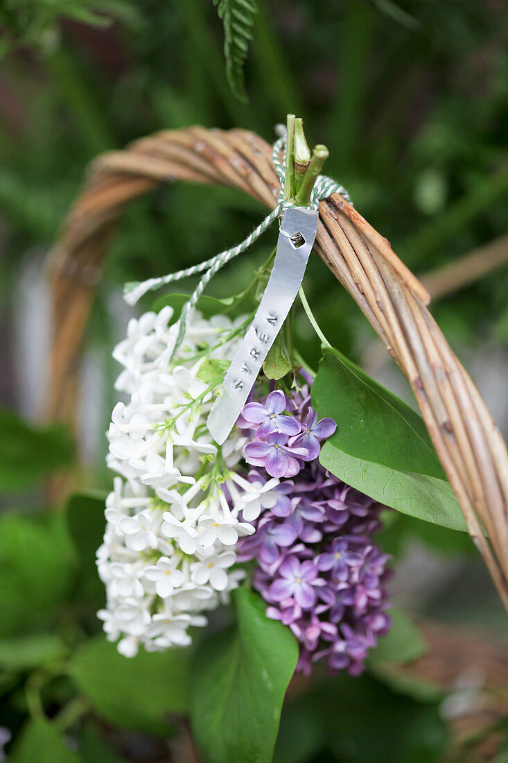 Purple and white lilac tied to basket handle