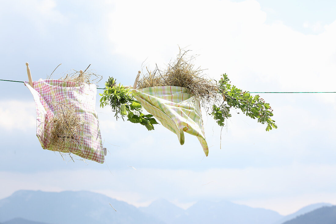 Hay in cloth bags and herbs on a clothesline