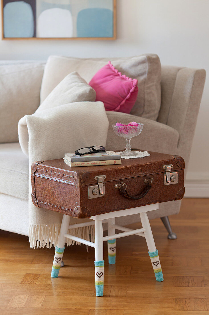 Side table made from old suitcase and stool with chair socks