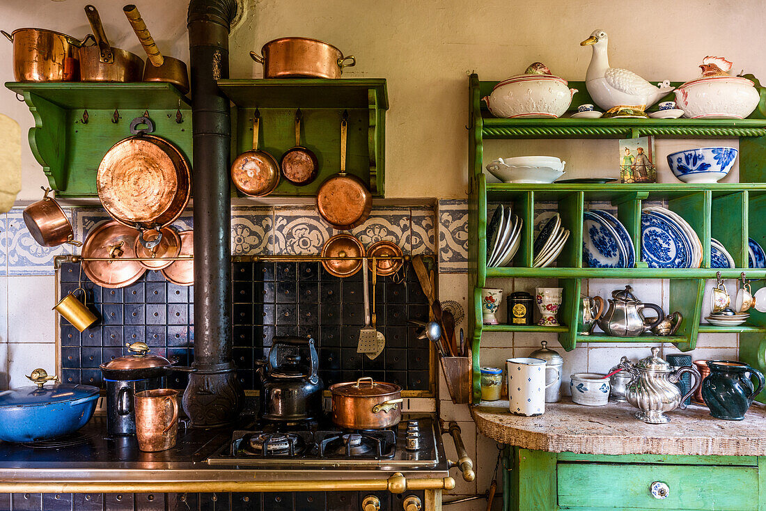 Rustic kitchen with hanging copper pans and plate rack