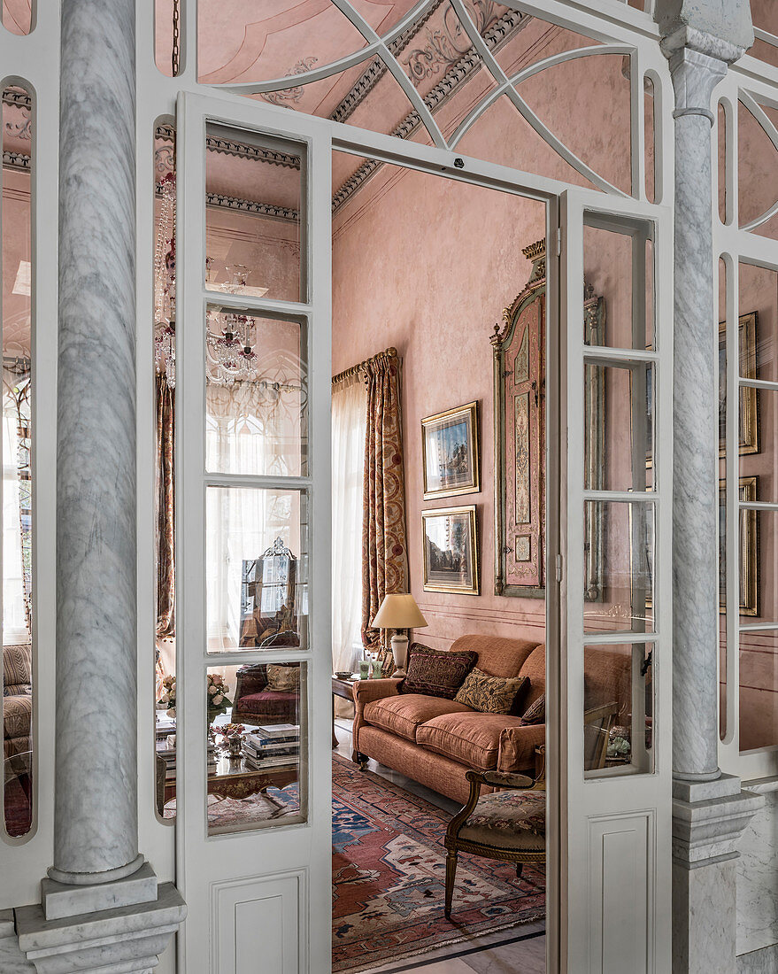 View through open lattice door into opulent pink living room