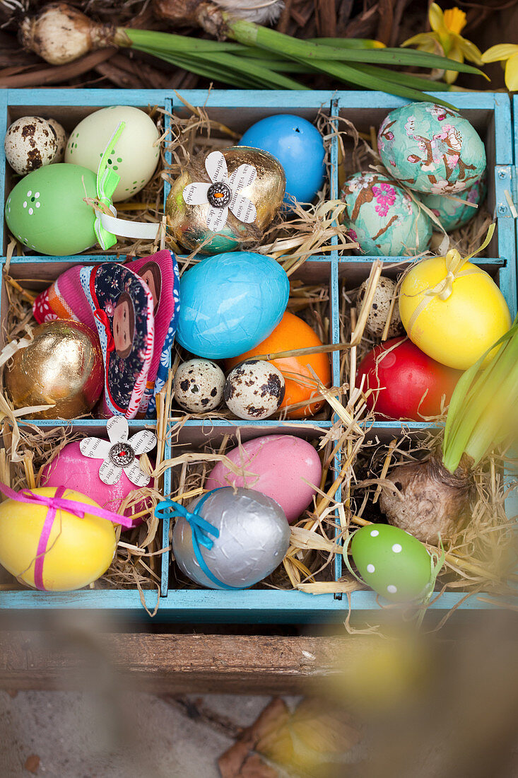 Colourful Easter eggs in wooden crate