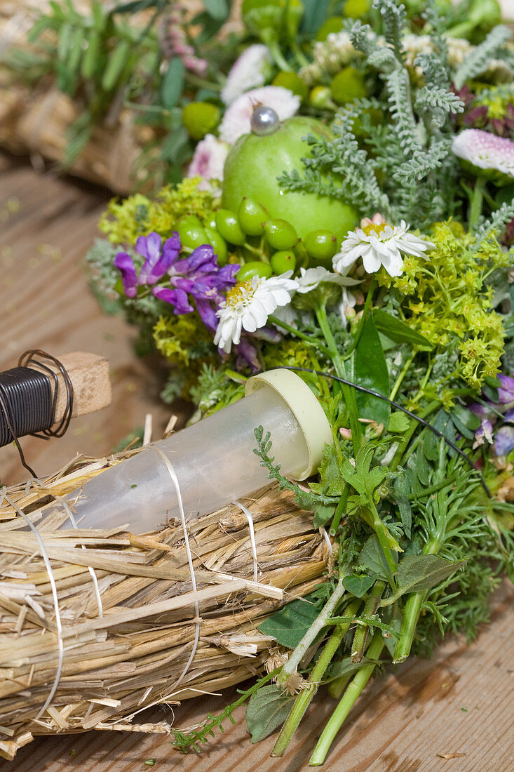 Incorporating florists' water vials into summer wreath