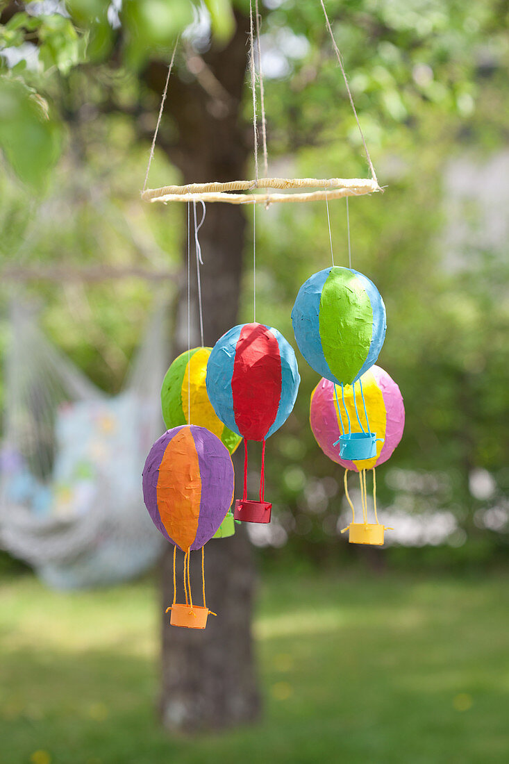 Homemade mobile with colorful hot air balloons in the garden