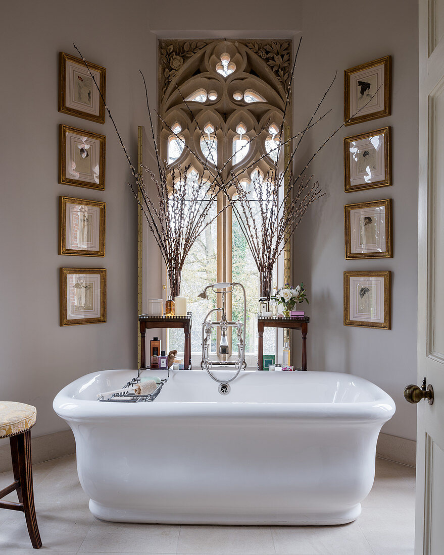 Freistehende Badewanne vorm gotischen Fenster im klassischen Bad