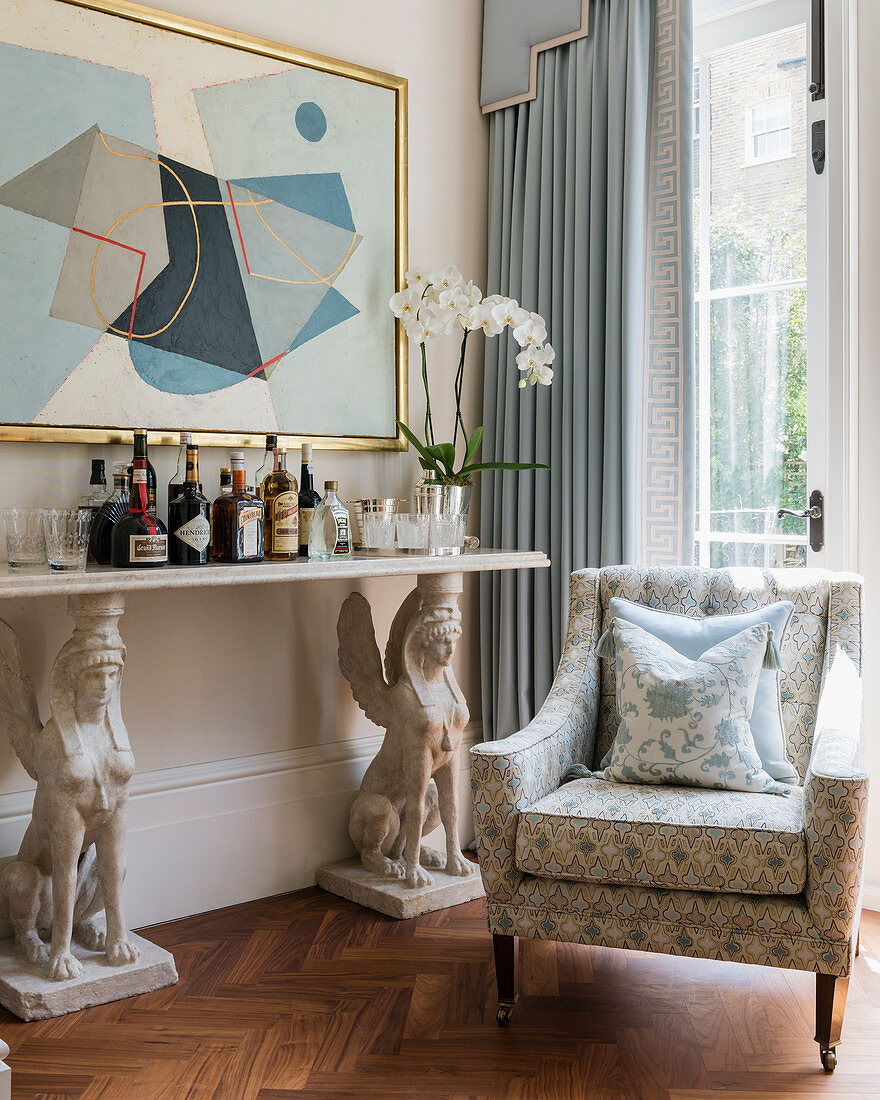 Home bar on console table borne by two sphinxes in living room