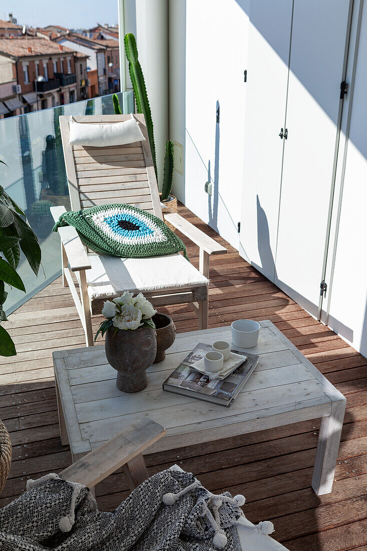 Tisch und Holzstuhl auf sonniger Terrasse im Obergeschoss