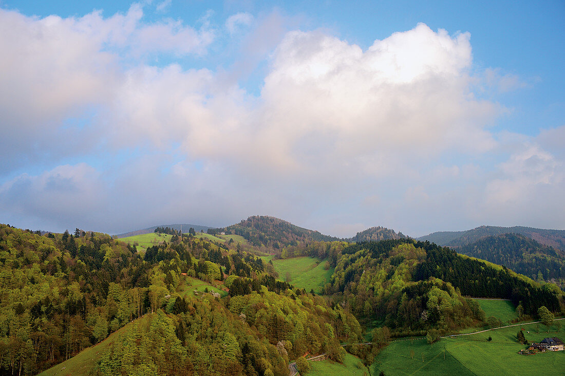 Grüne Berglandschaft, blauer Himmel mit Wolken