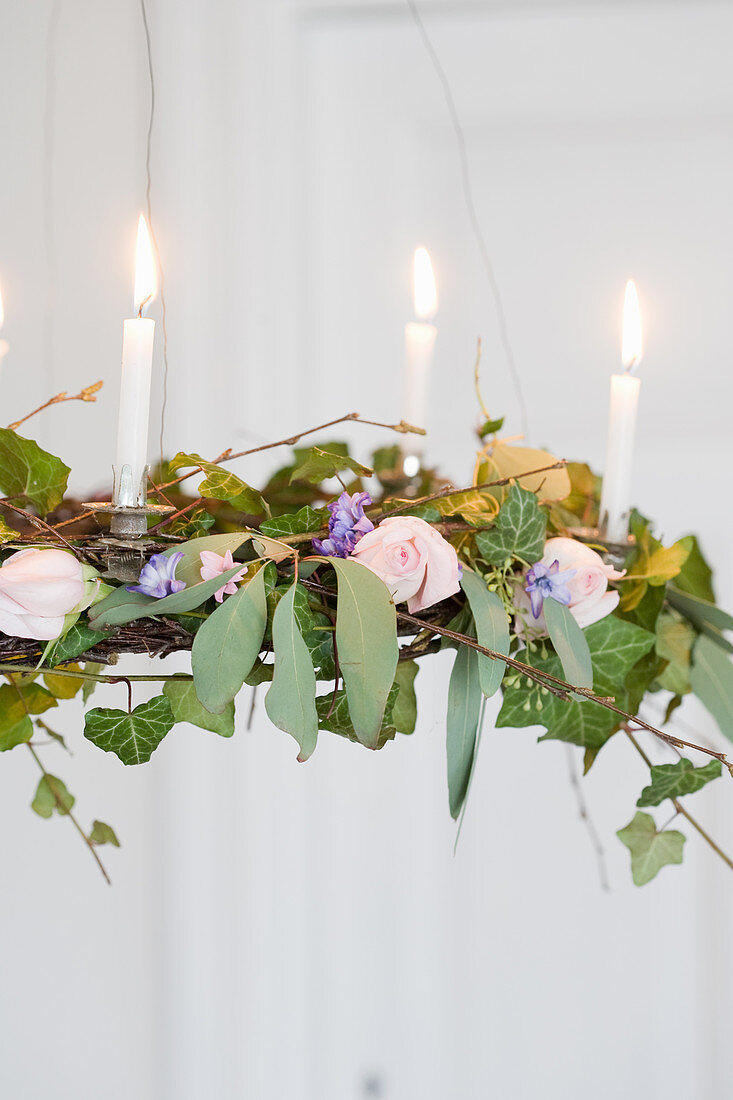 Chandelier with candles, ivy, eucalyptus, roses, and hyacinths