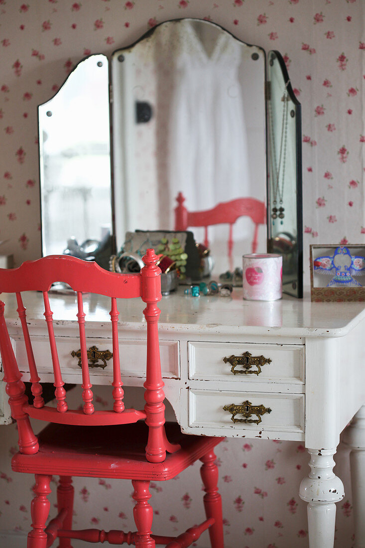 Roter gedrechselter Stuhl am alten Schminktisch mit Standspiegel