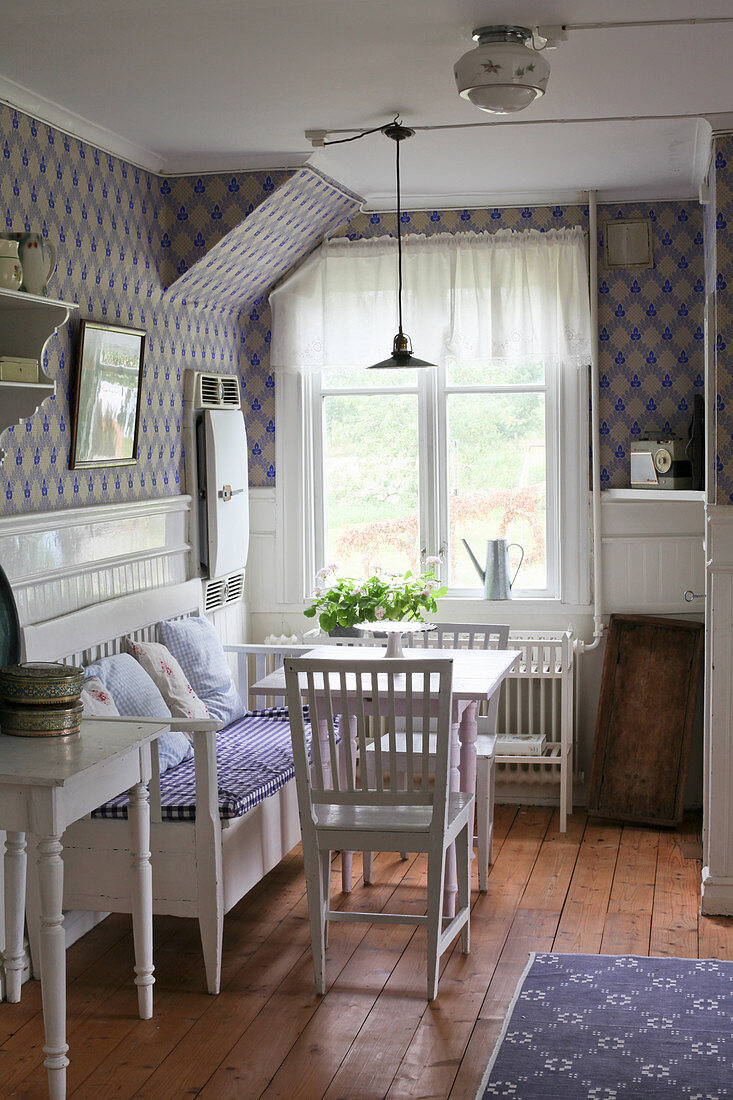 Scandinavian-style dining room with patterned wallpaper and wainscoting