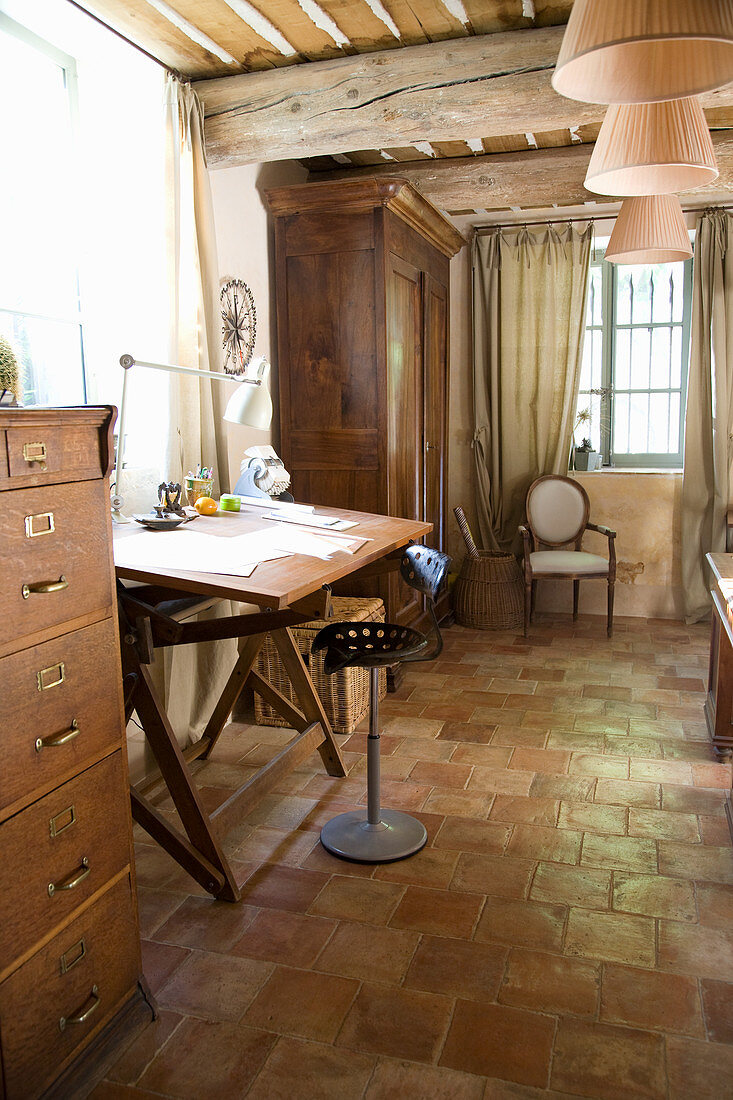 Swivel chair at the desk in the rustic living room with terracotta tiles