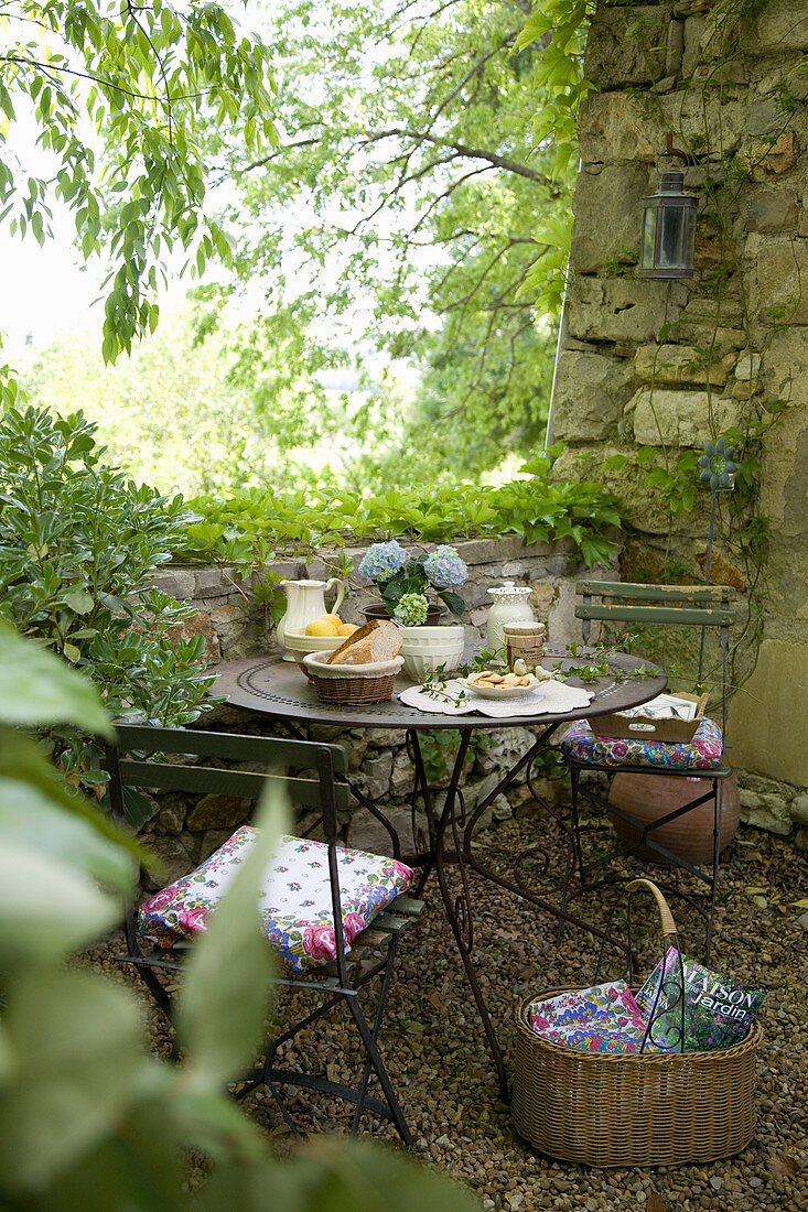 Set table in an enchanted garden with a natural stone wall
